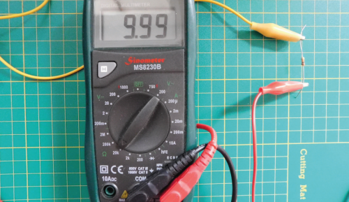 A multimeter showing the figure 9.99 with a resistor connected via crocodile clips