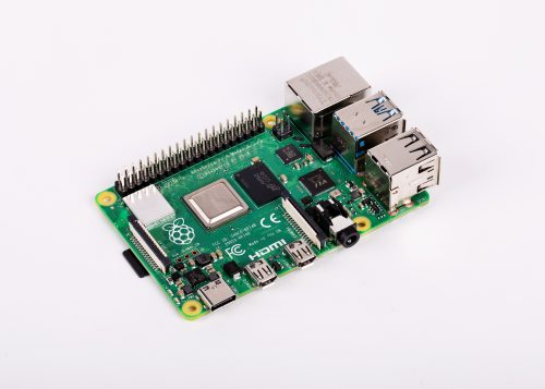 A shiny Raspberry Pi 4 on a flat white surface, viewed at an angle