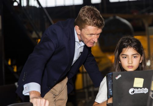 Tim Peake observes a girl writing code that will run in space