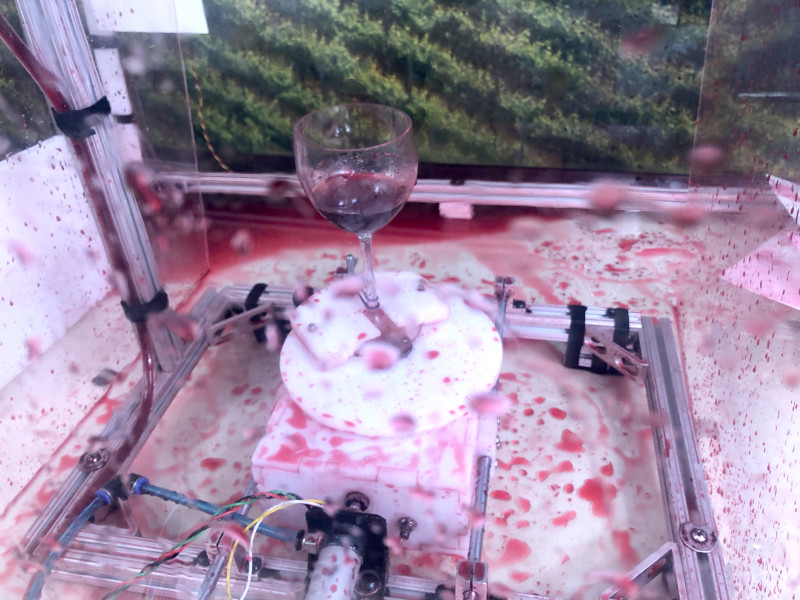 The wine glass spins on a turntable, creating unique splatter art