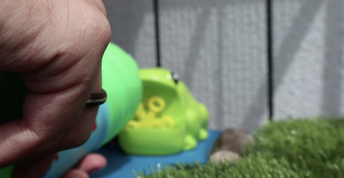 Bubble soap being poured into the plastic frog's mouth