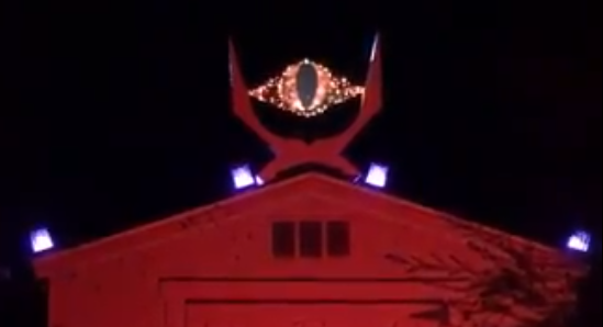 The eye of sauron on top of a barn lit in red lights