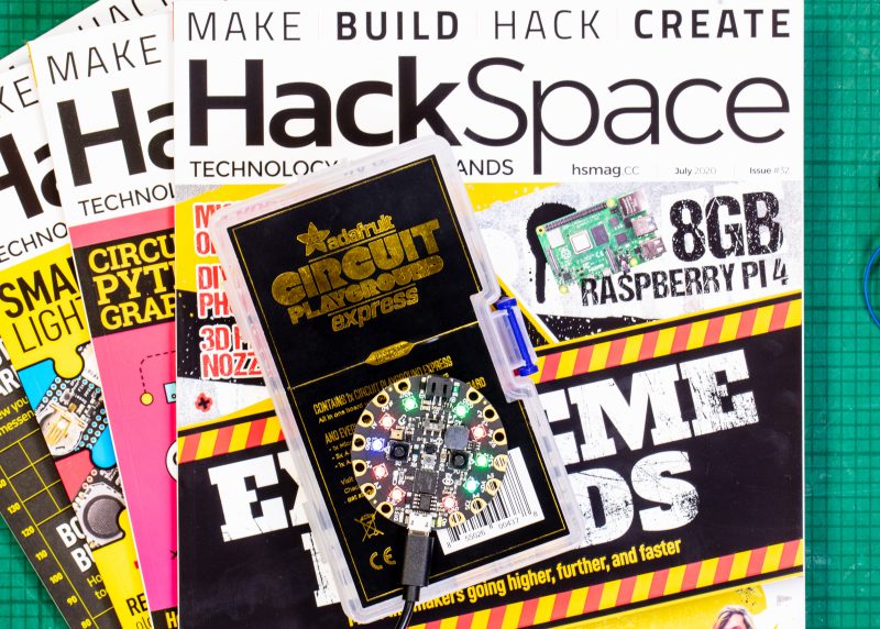 Hackspace magazines fanned out with adafruit gift on top