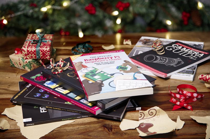 A selection of Raspberry Pi books on a table surrounded by Christmas decorations