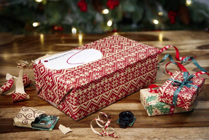 a raspberry pi 400 box peeking out of christmas wrapping paper