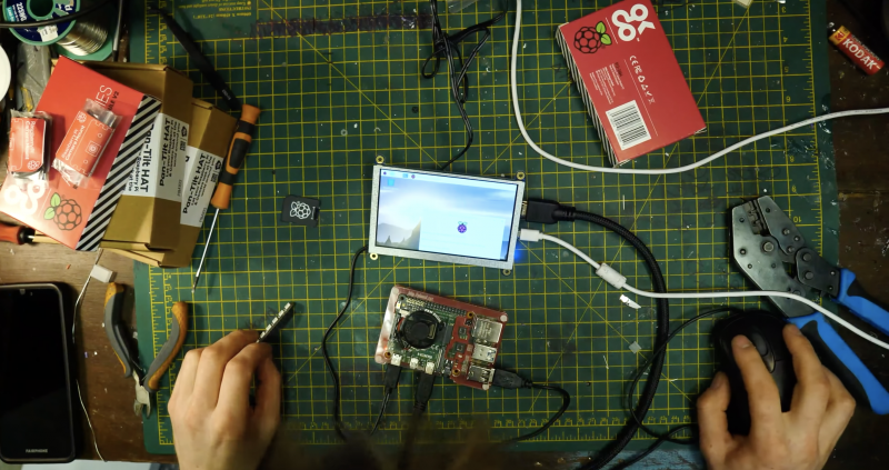 Raspberry Pi with camera module attached to small screen loading software needed to run face recognition