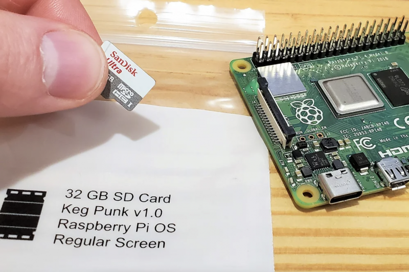 a raspberry pi 4 next to an s d card being held 