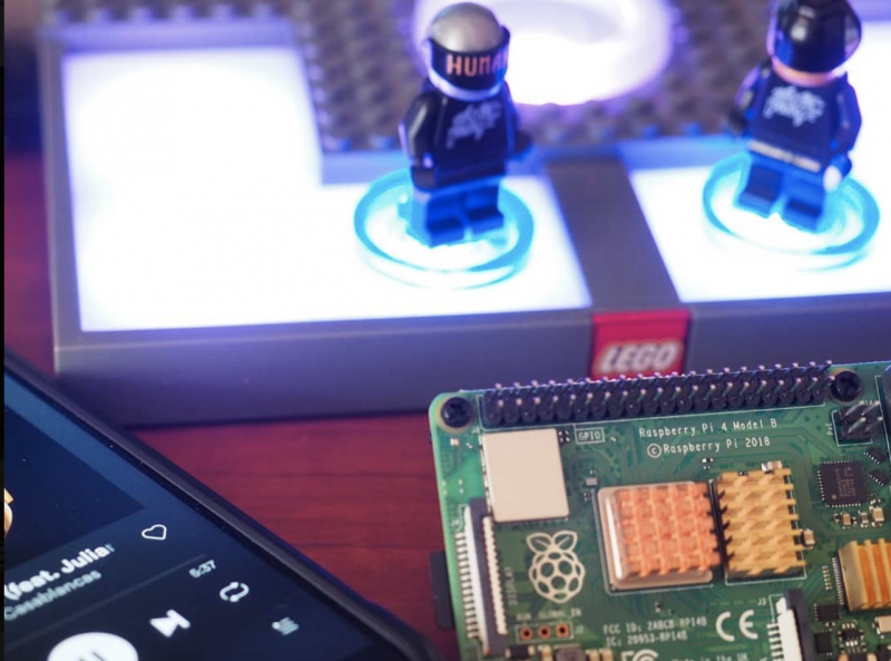Daft Punk LEGO minifgures stood on an NFC reader next to a Raspberry Pi and a phone showing Daft Punk playing on Spotify