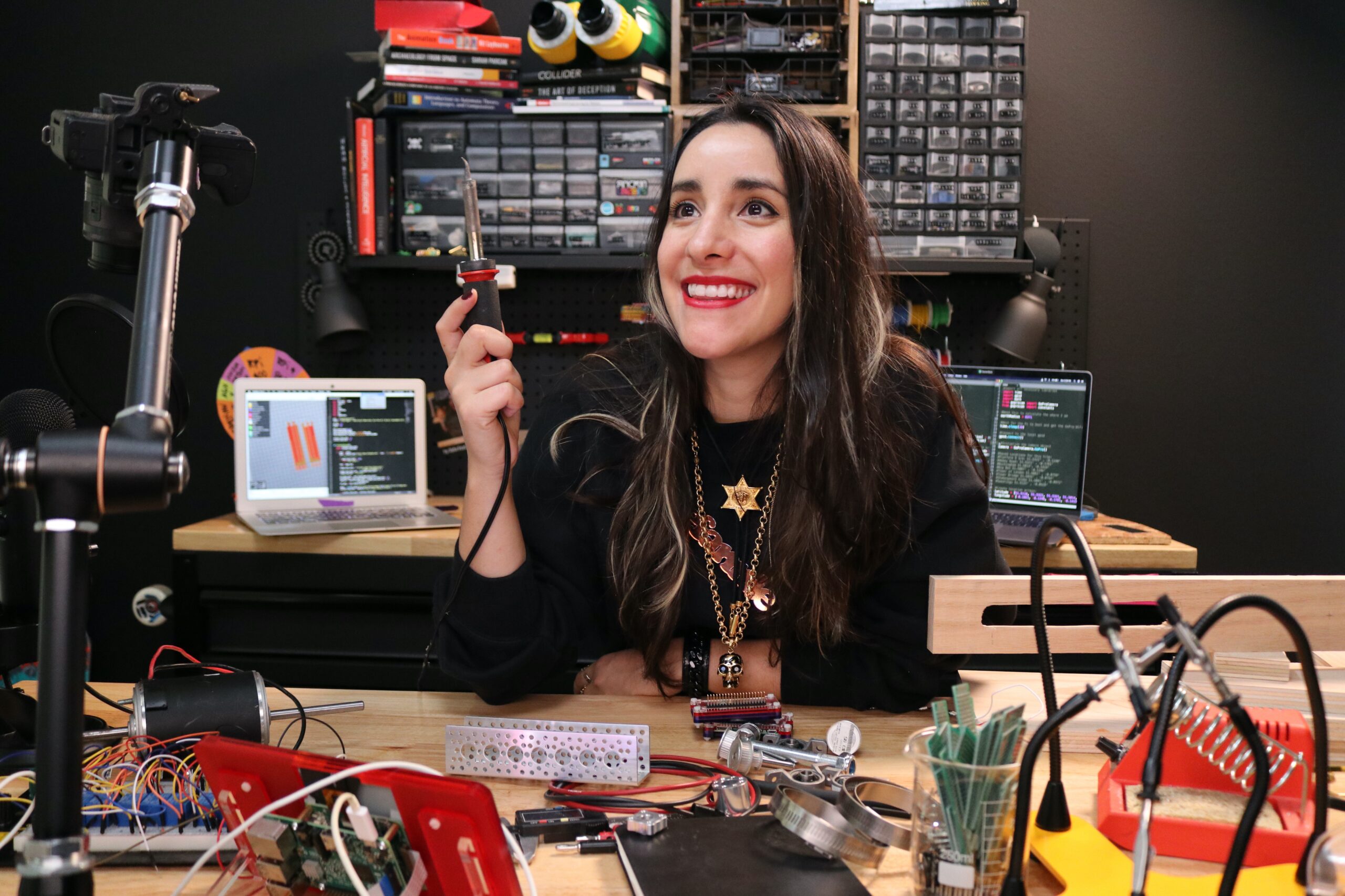 Estefannie with soldering iron at her desk