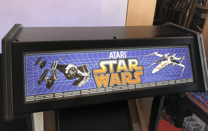 header of the arcade cabinet bearing a Star Wars logo