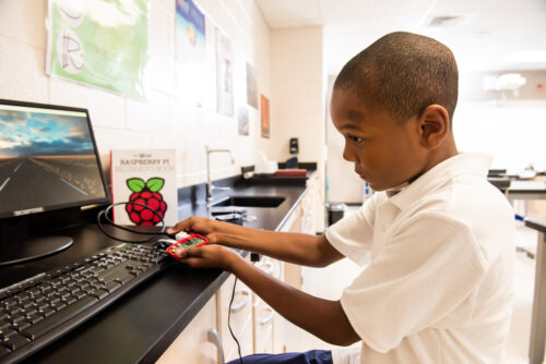 A Black boy uses a Raspberry Pi computer at school.