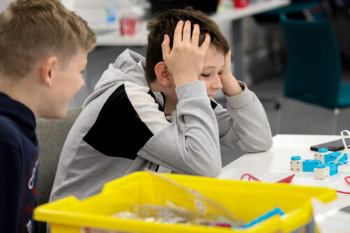 Two young people work as a team at a CoderDojo coding club.