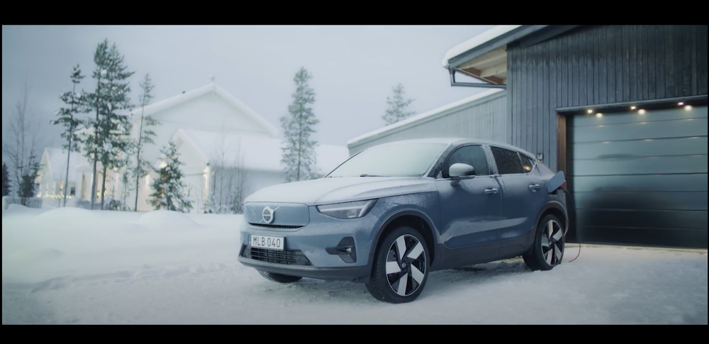 Video showing woman using remote actions to pre-warm her car before setting off on a drive in the snow.