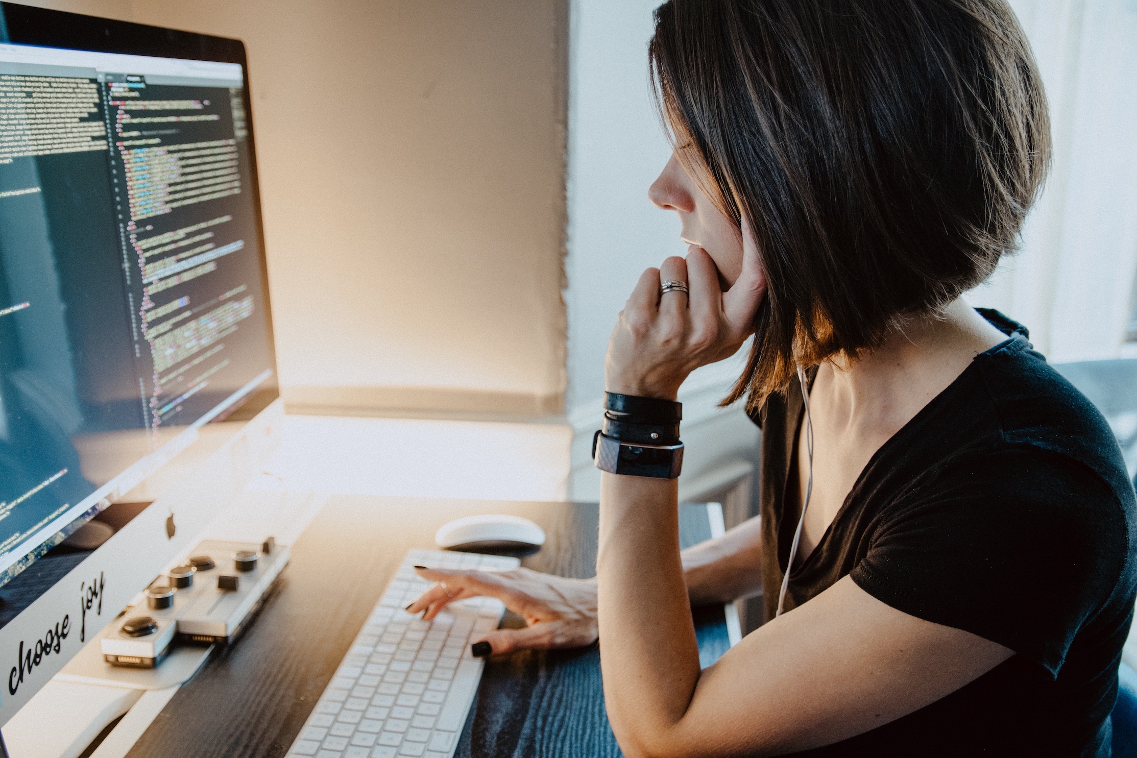 A woman works at a desktop computer.