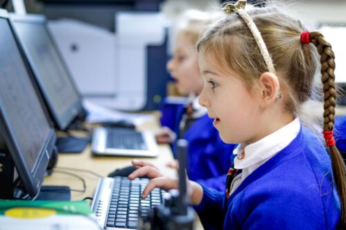 Two learners writing programs on their computers.