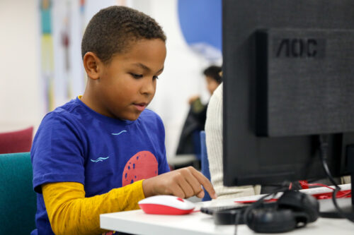 A boy types code at a CoderDojo coding club.
