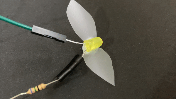 Une LED clignotante avec des ailes en papier. 