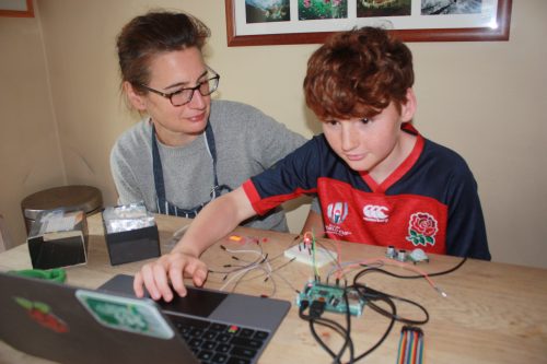 A parent and young person work on a digital making project at home. 