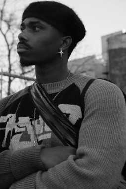 Profilbild des Künstlers Clif Wilson, der einen Pullover trägt – im Hintergrund ist ein Baum zu sehen.